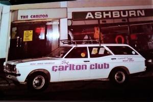 A white car with purple lettering

Description automatically generated